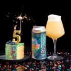 lata e copo cerveja artesanal Ophiussa ophidian new england triple IPA 44 cl com fatia de bolo e vela com o numero 5, estrela de luz e confetis